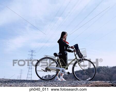 School girl holding a bicycle View Large Photo Image Stock Image - School girl holding a bicycle. Fotosearch