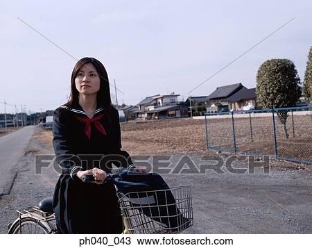 School girl holding a bicycle View Large Photo Image Stock Image - School girl holding a bicycle. Fotosearch