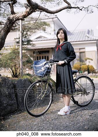 School girl holding a bicycle View Large Photo Image Stock Photo - School girl holding a bicycle. Fotosearch