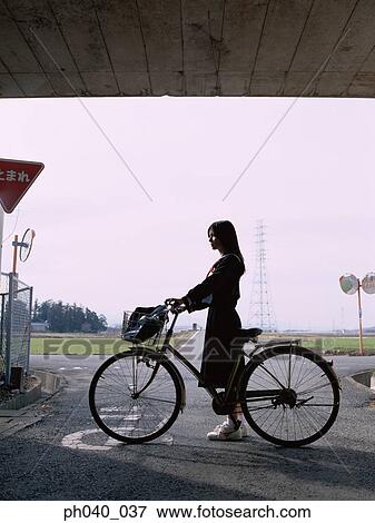 School girl holding a bicycle View Large Photo Image Stock Photo - School girl holding a bicycle. Fotosearch