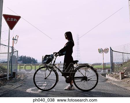 School girl holding a bicycle View Large Photo Image Stock Photo - School girl holding a bicycle. Fotosearch