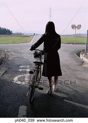 School girl holding a bicycle View Large Photo Image Stock Photo - School girl holding a bicycle. Fotosearch