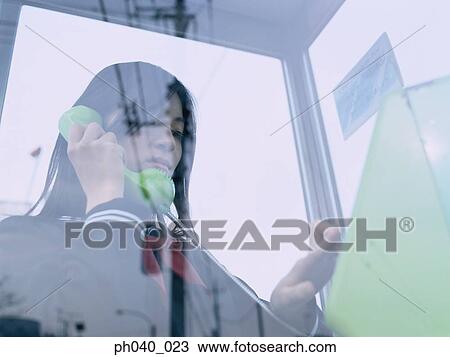 School girl making a phone call in a public phone booth View Large Photo Image Stock Image - School girl making a phone call in a public phone booth. Fotosearch