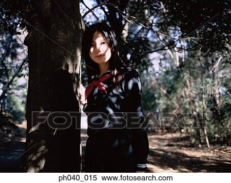 School girl standing besides a tree View Large Photo Image Stock Photography - School girl standing besides a tree. Fotosearch
