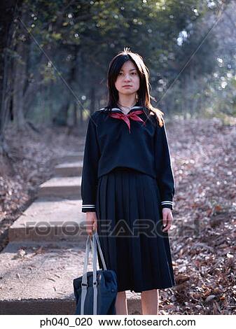 Stock Image - School girl standing on the steps. Fotosearch