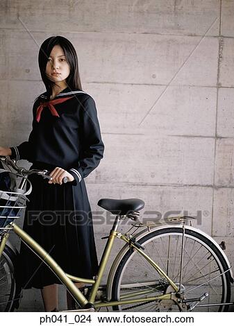 Picture - School girl holding a bicycle. Fotosearch