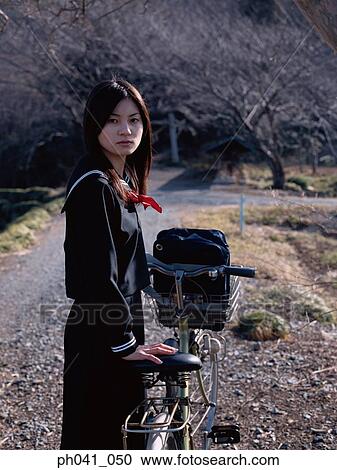 School girl holding a bicycle View Large Photo Image Stock Image - School girl holding a bicycle. Fotosearch