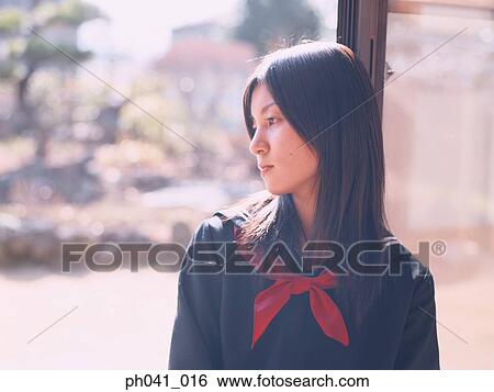 Stock Photograph - School girl leaning against a door. Fotosearch
