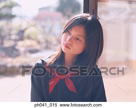 Stock Photography - School girl leaning against a door. Fotosearch