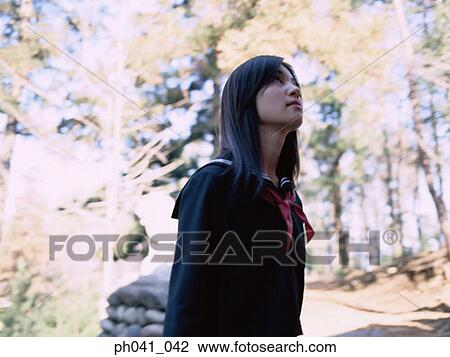 Stock Image - School girl looking up. Fotosearch