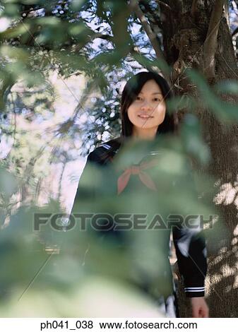 Stock Photo - School girl standing in the park. Fotosearch