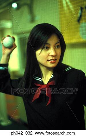 Stock Image - School girl holding a baseball. Fotosearch