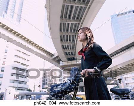 School girl holding a bicycle View Large Photo Image Picture - School girl holding a bicycle. Fotosearch