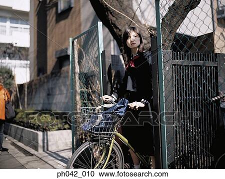 School girl holding a bicycle View Large Photo Image Stock Image - School girl holding a bicycle. Fotosearch