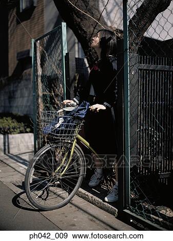 School girl holding a bicycle View Large Photo Image Stock Photo - School girl holding a bicycle. Fotosearch