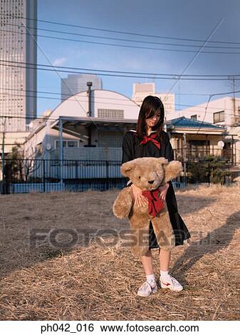 Stock Photograph - School girl holding a toy bear. Fotosearch