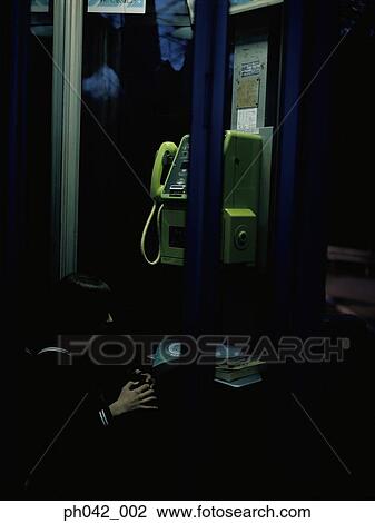 Stock Image - School girl in a public telephone booth. Fotosearch