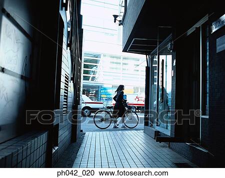 School girl pushing a bicycle View Large Photo Image Stock Image - School girl pushing a bicycle. Fotosearch