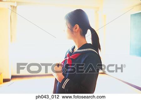 Stock Image - School girl cleaning the classroom. Fotosearch