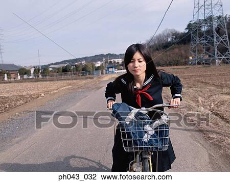 Stock Image - School girl cycling. Fotosearch