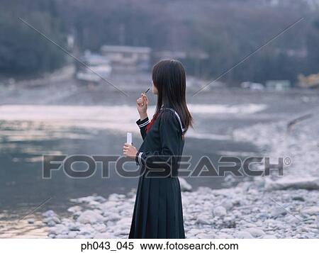 Stock Photography - School girl eating snacks. Fotosearch