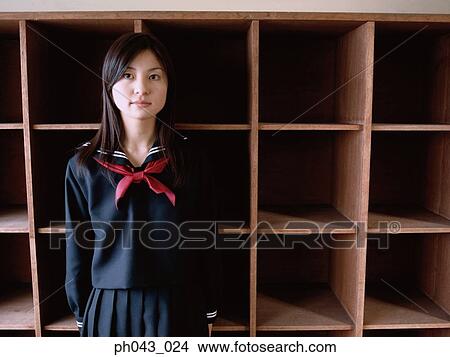 Picture - School girl leaning against a shelve. Fotosearch