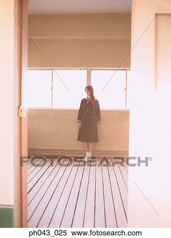 Stock Photography - School girl standing in a classroom. Fotosearch
