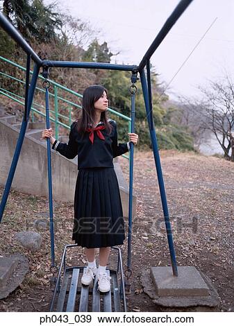 School girl standing on a swing View Large Photo Image Stock Photo - School girl standing on a swing. Fotosearch