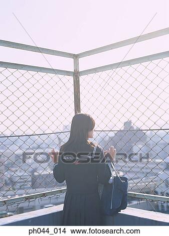 School girl holding on the fence View Large Photo Image Picture - School girl holding on the fence. Fotosearch