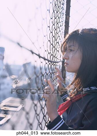 School girl holding on the fence View Large Photo Image Stock Image - School girl holding on the fence. Fotosearch