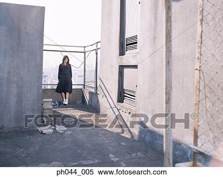 Stock Photography - School girl leaning against a fence. Fotosearch