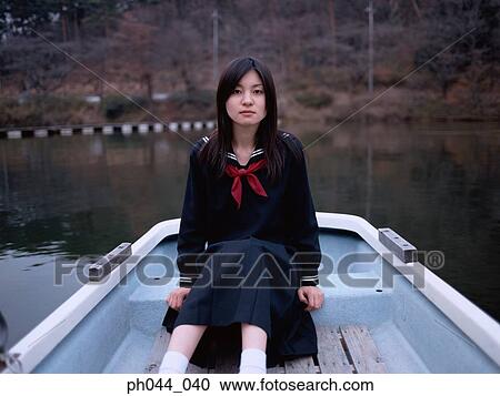 Stock Image - School girl sitting in a boat. Fotosearch