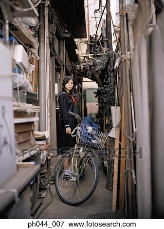 School girl standing in an alley View Large Photo Image Stock Photo - School girl standing in an alley. Fotosearch
