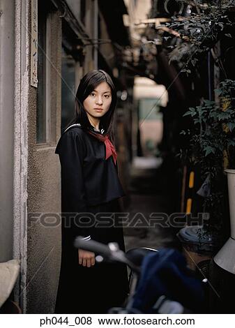 Stock Photo - School girl standing in an alley. Fotosearch