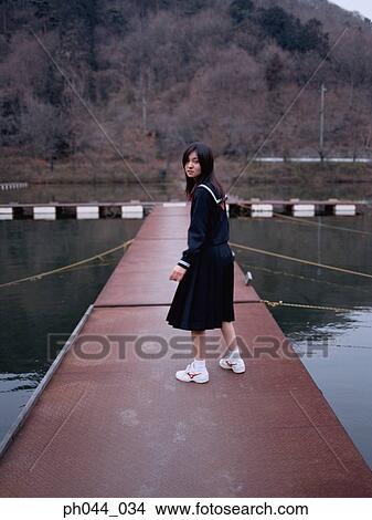 Picture - School girl standing on the pathway. Fotosearch