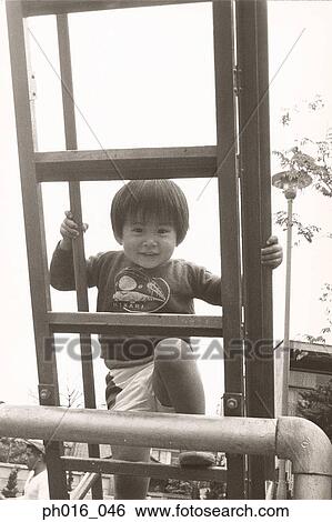 Stock Photograph - Boy climbing up a ladder. Fotosearch
