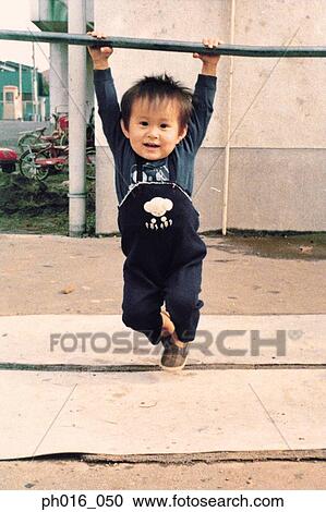 Boy hanging on a monkey bar View Large Photo Image Stock Image - Boy hanging on a monkey bar. Fotosearch