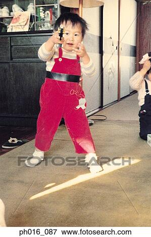 Boy playing at home with a toy gun View Large Photo Image Stock Photo - Boy playing at home with a toy gun. Fotosearch