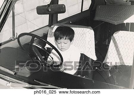 Stock Photography - Boy playing in the driver's seat. Fotosearch