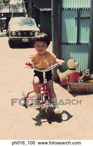 Stock Image - Boy riding on a tricycle. Fotosearch