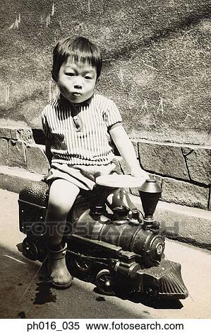 Boy sitting on a toy train View Large Photo Image Stock Photography - Boy sitting on a toy train. Fotosearch