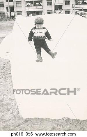 Stock Photograph - Boy sliding down a slide. Fotosearch