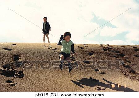 Boys playing on a sandy slope View Large Photo Image Stock Image - Boys playing on a sandy slope. Fotosearch