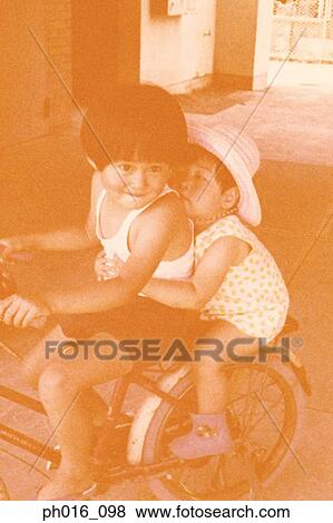 Children riding a tricycle View Large Photo Image Stock Photo - Children riding a tricycle. Fotosearch