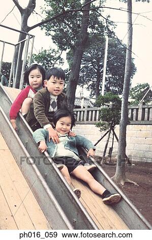 Stock Photo - Children sliding down a slide. Fotosearch