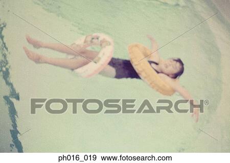 Girl floating on a swimming pool View Large Photo Image Stock Photo - Girl floating on a swimming pool. Fotosearch