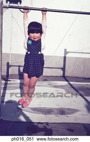 Girl hanging on a monkey bar View Large Photo Image Stock Image - Girl hanging on a monkey bar. Fotosearch