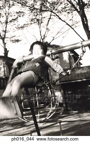 Picture - Girl playing on a swing. Fotosearch