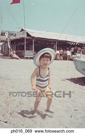 Stock Photo - Girl standing on a beach. Fotosearch