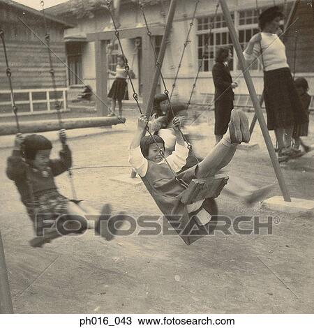 Girls playing on swings in a playground View Large Photo Image Stock Image - Girls playing on swings in a playground. Fotosearch